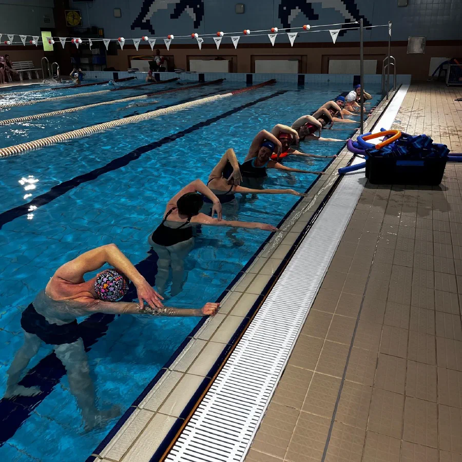 Rozciąganie i stretching przy brzegu basenu po części głównej treningu