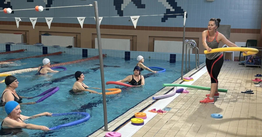 Prowadzenie ćwiczeń w wodzie przez instruktorkę z makaronem wypornościowym