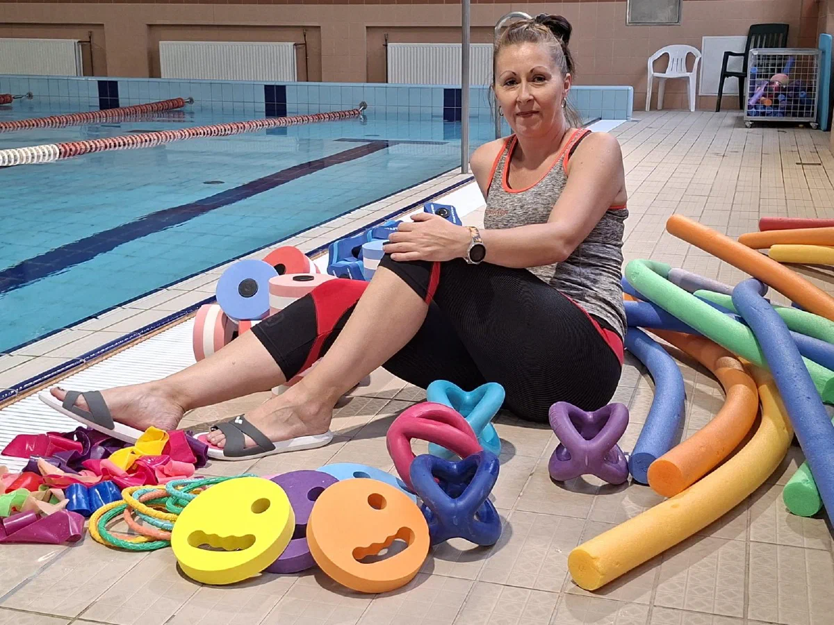 Anna Pałaszyńska przy brzegu basenu z kolorowym sprzętem do aqua fitness